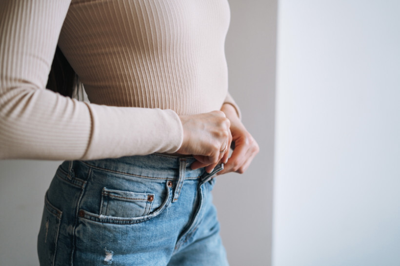 slim vs skinny jeans - Woman in slim-fit jeans standing