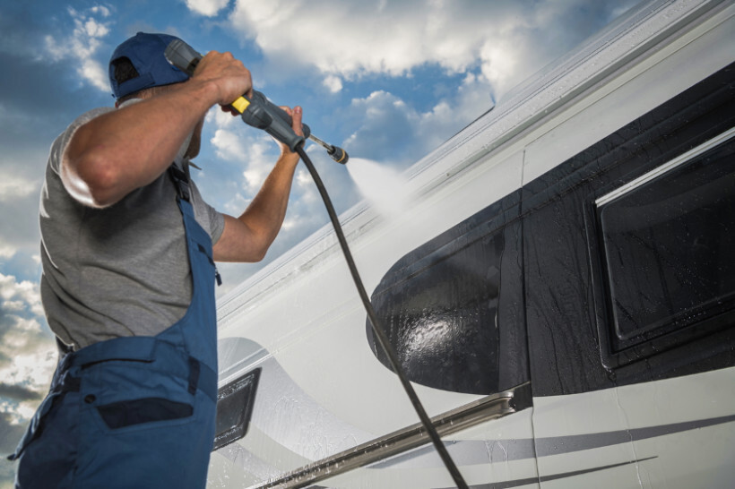 power washer vs pressure washer - Man using a power washer on his car