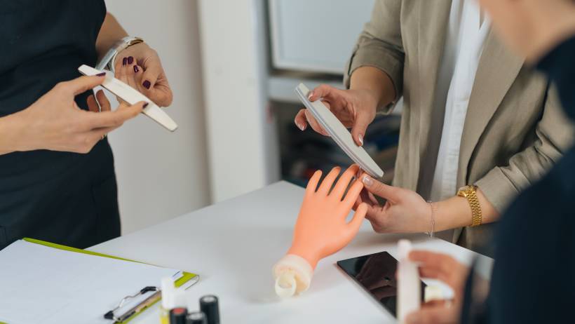 A professional demonstrating proper nail filing for nail tech trainees. - nail technician vs manicurist