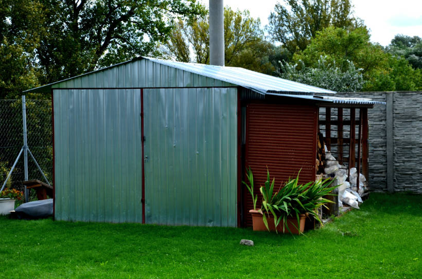 metal vs wood shed - durable metal shed in a green backyard, providing a practical storage solution for outdoor essentials