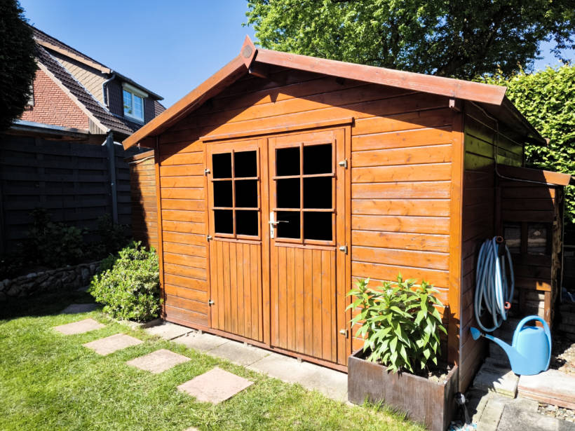 metal vs wood shed - charming wood shed in a backyard garden, providing an eco-friendly storage solution