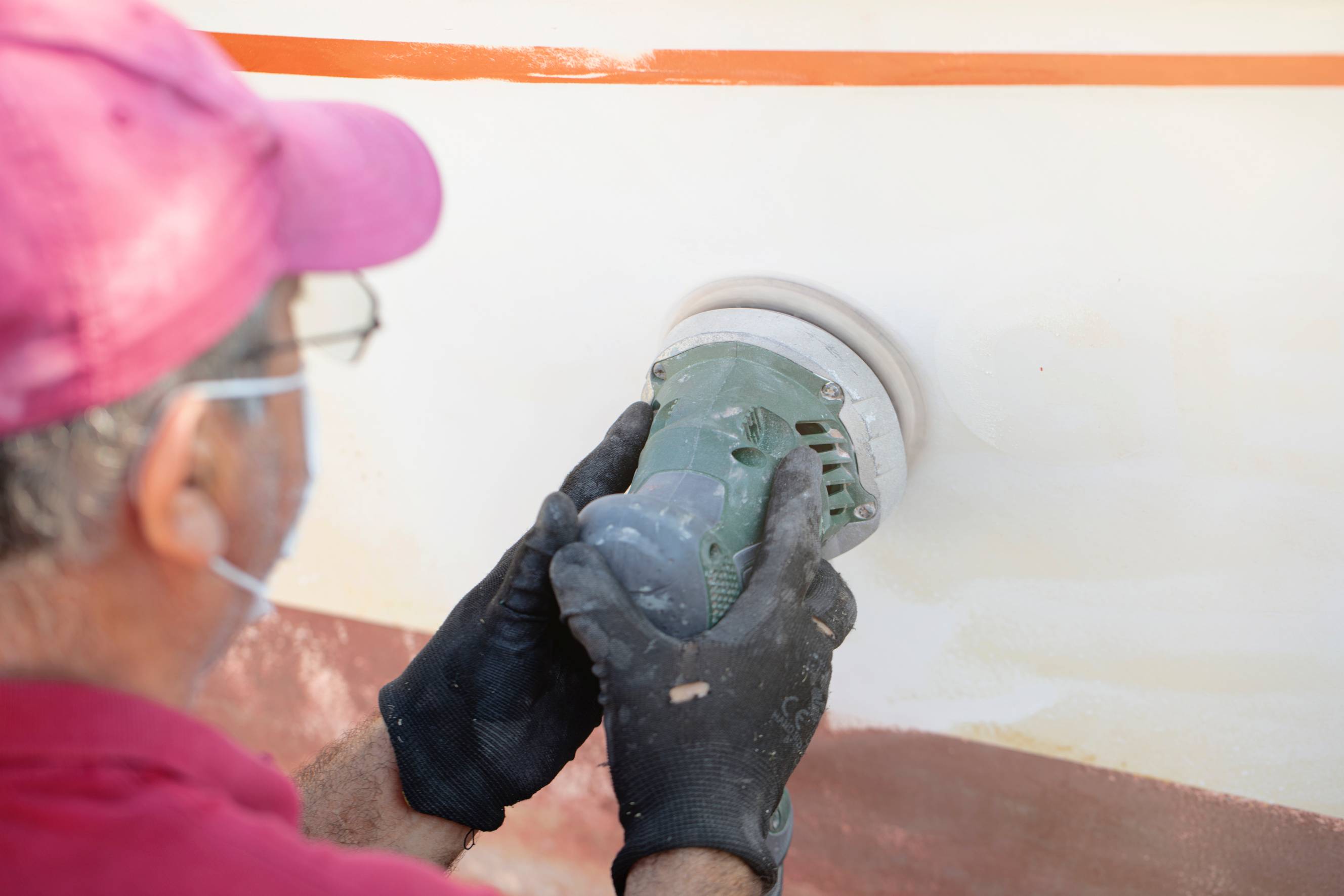 A professional contractor doing fiberglass repair on a fiberglass boat.