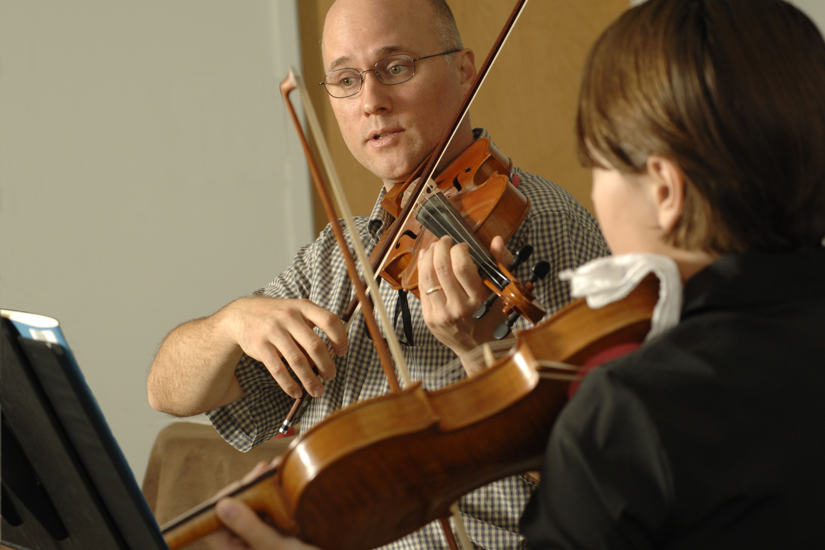 Experienced violin instructor teaching a student during a lesson, representing professional violin lessons near you.