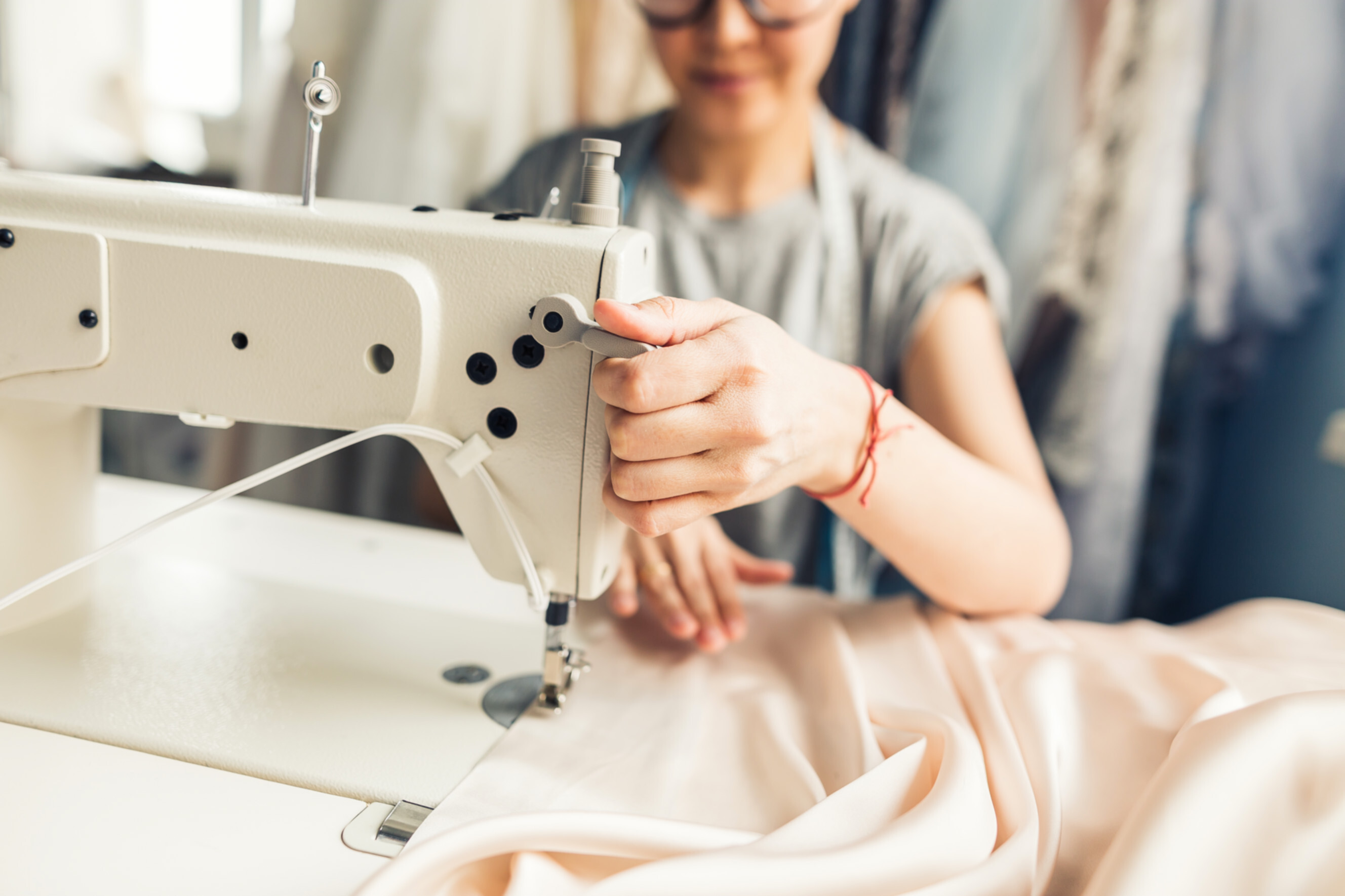 Skilled seamstress working on fabric with a sewing machine, showcasing professional sewing and alteration services near you.