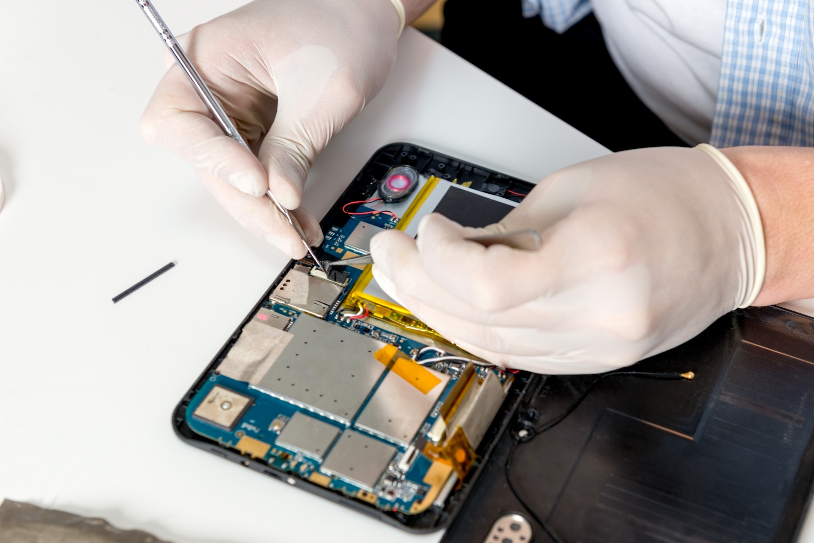 Technician carefully repairing a tablet’s internal components, showcasing professional tablet repair technicians near you.