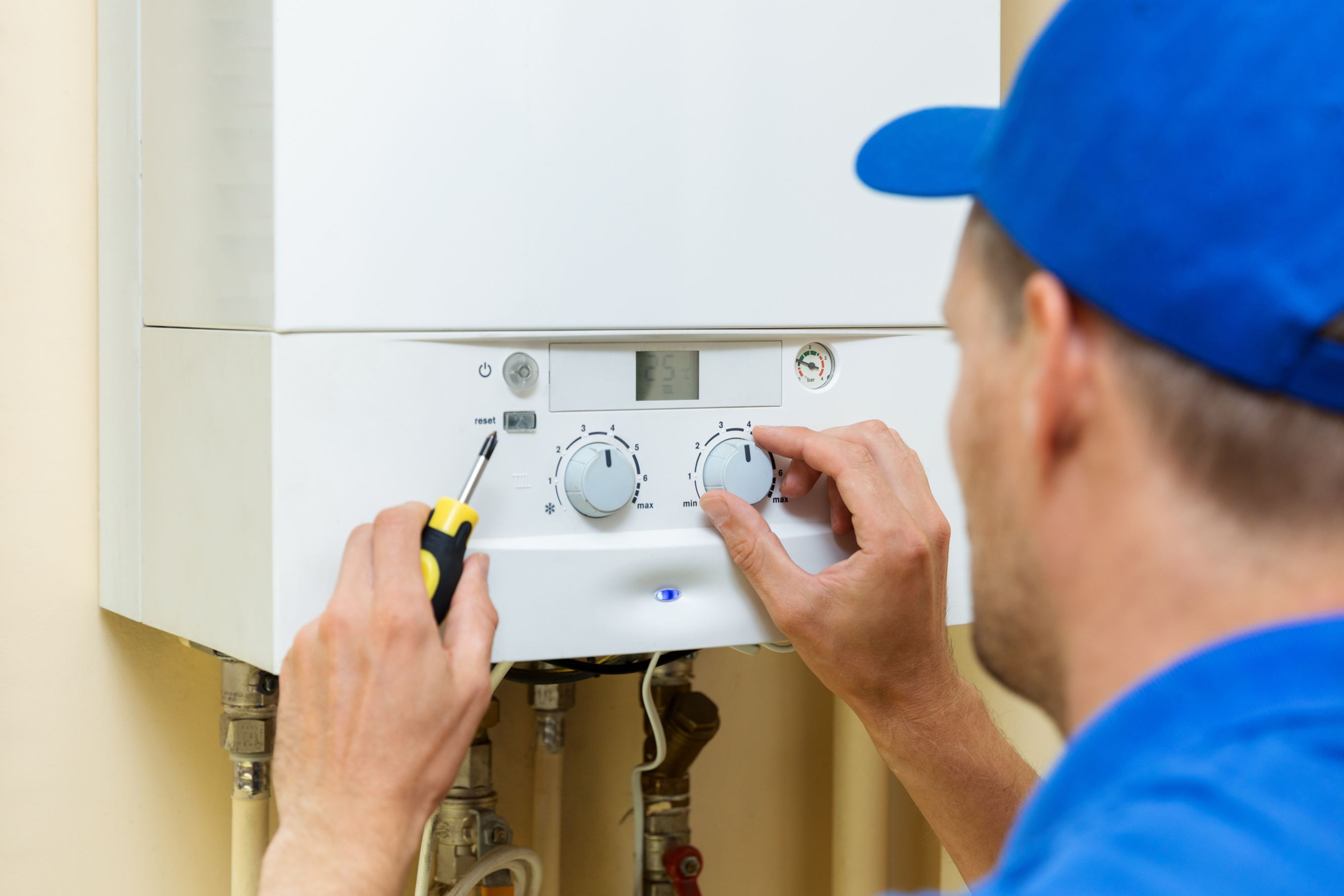 A worker setting up a central gas water heater at home.