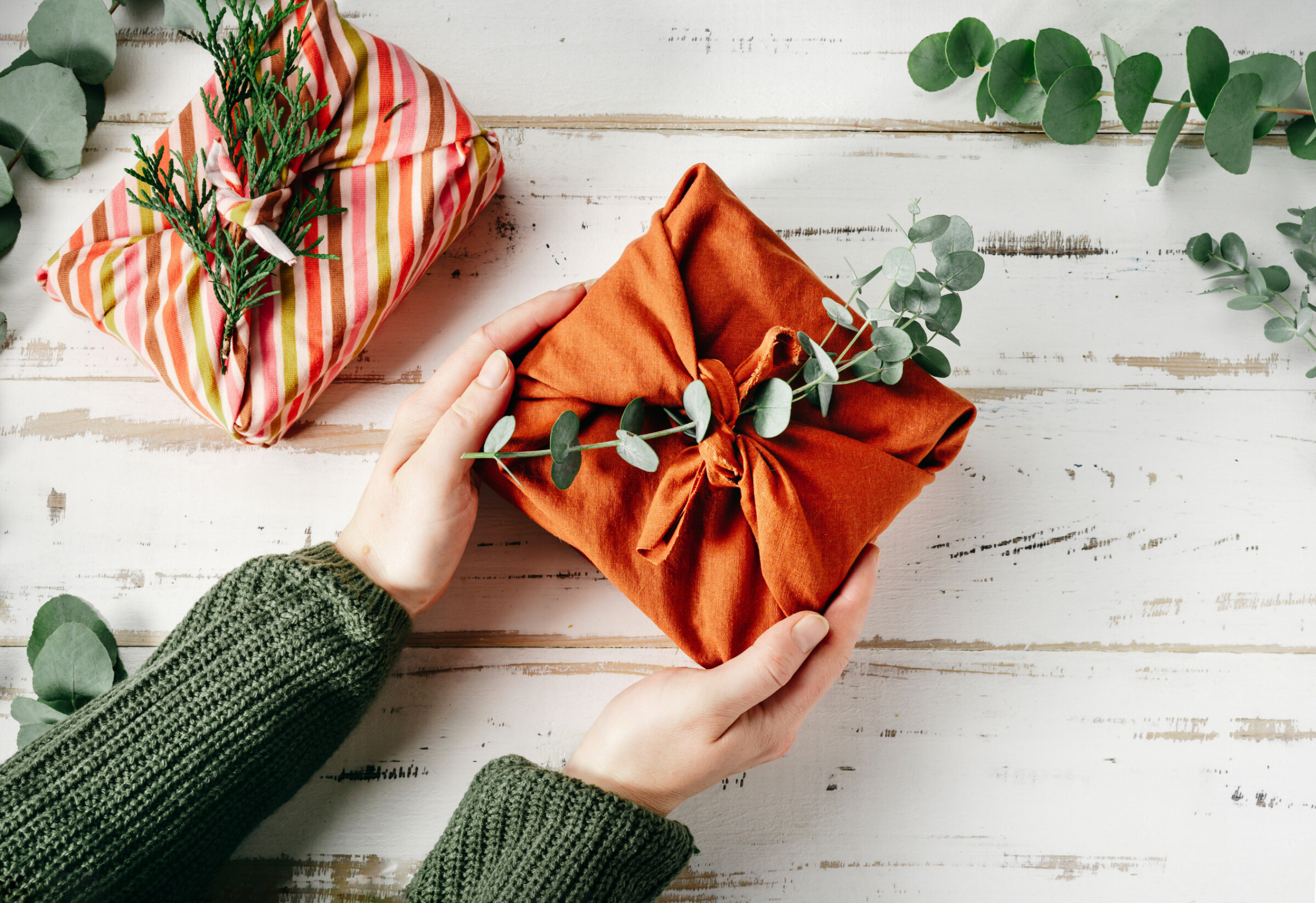 Wrapping a gift in eco friendly reusable fabric package furoshiki