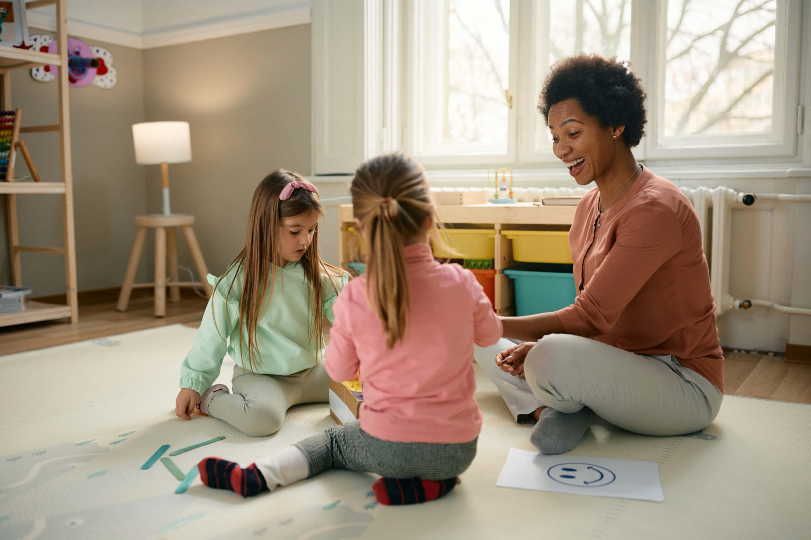 A nanny engaging children with fun activities at home.