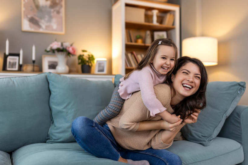 Nanny vs babysitter - A babysitter shares laughs and hugs with a happy child