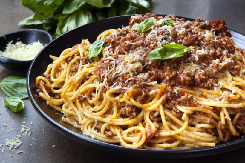 Ragù vs bolognese - Classic spaghetti bolognese topped with fresh basil and grated cheese