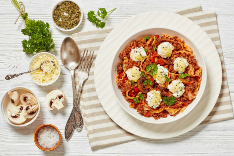 Ragù vs bolognese - Ragu served with dollops of ricotta and fresh herbs for a gourmet touch