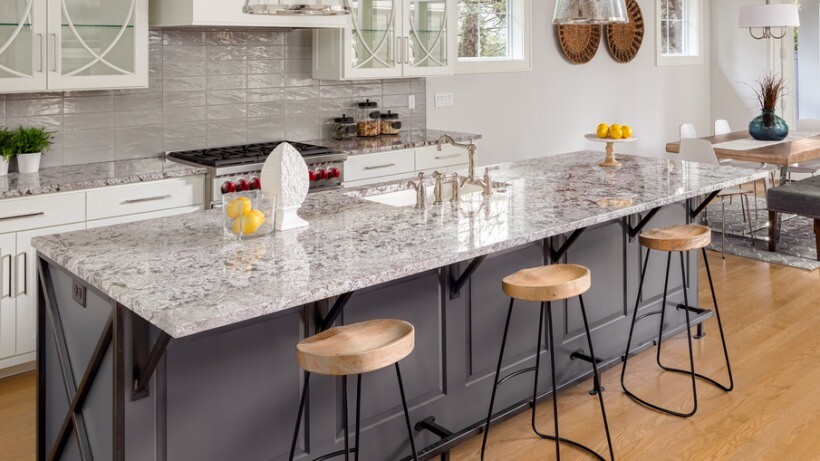 Quartz vs granite benchtops - A bright kitchen with a large granite benchtop showcasing intricate natural patterns