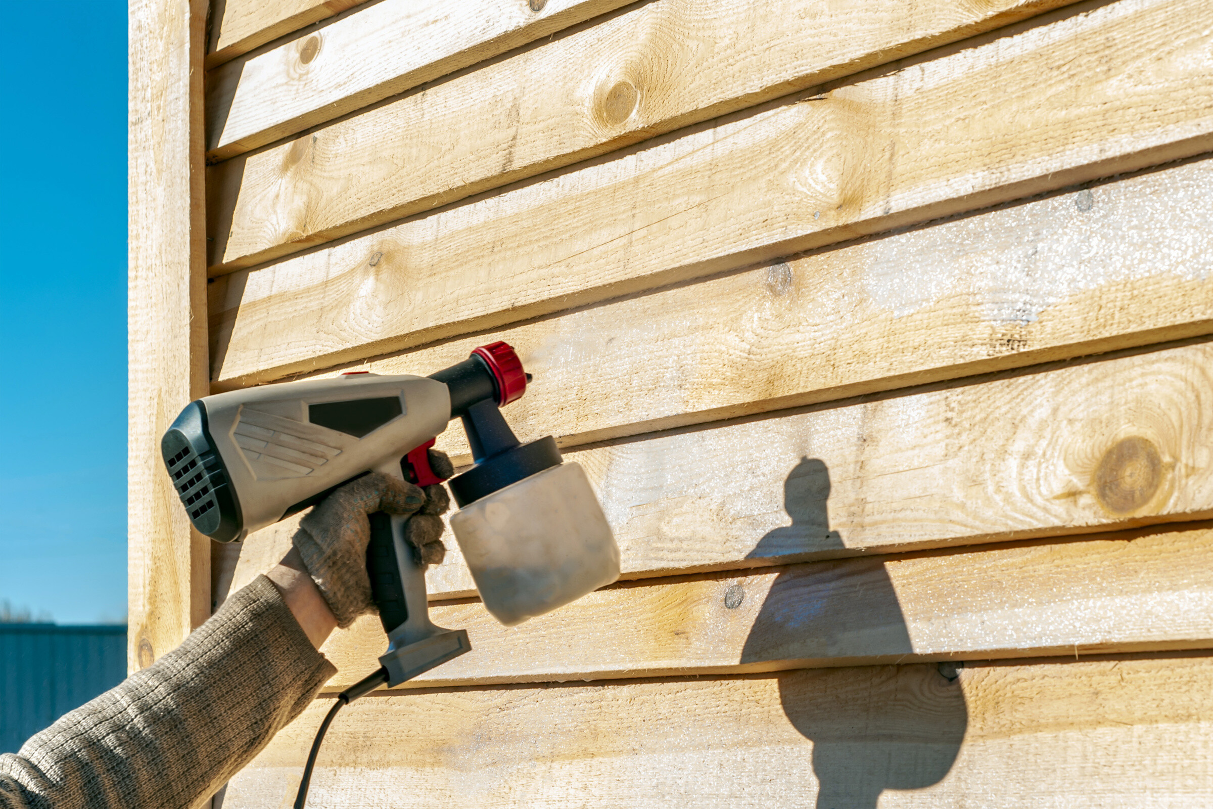 Side of a house being PVC sprayed.