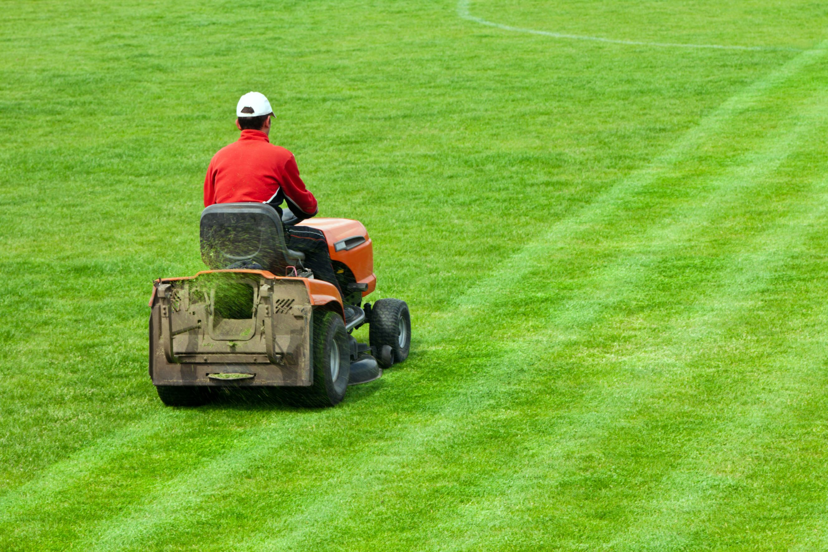 Caretaker mowing a soccer field.