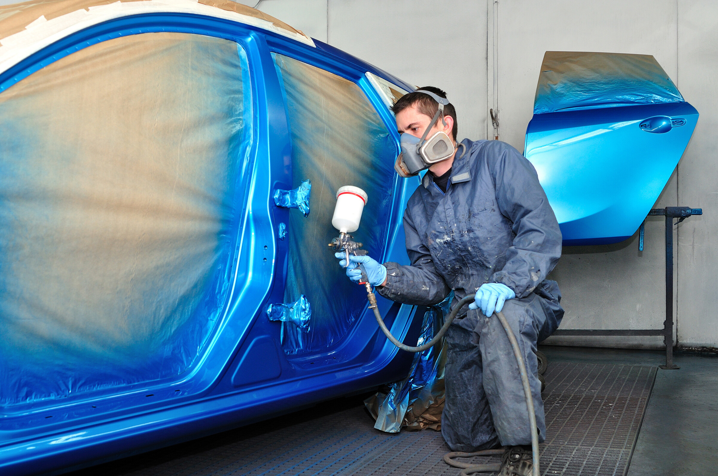 Profesional car painting in a paint booth.

