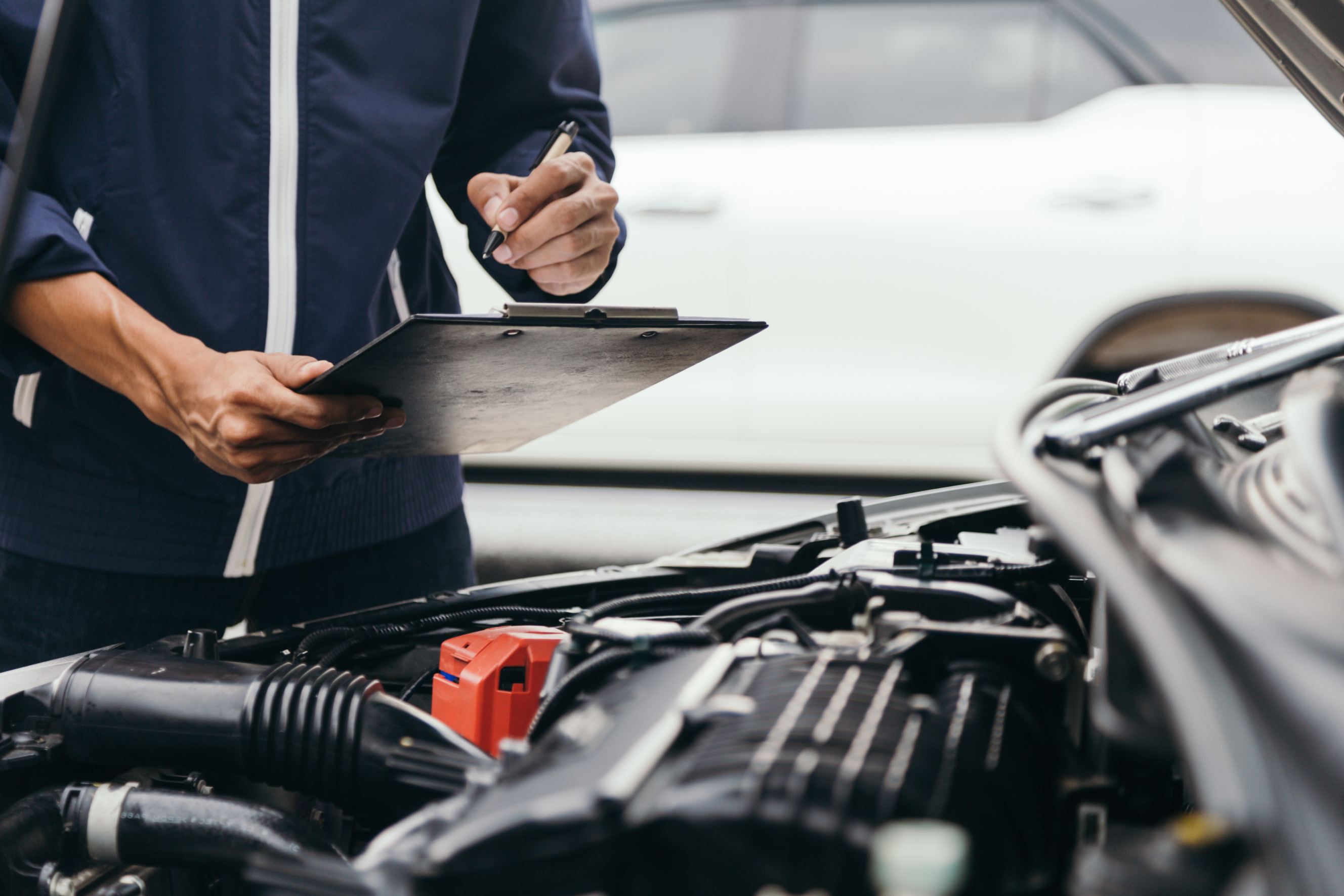 An automobile mechanic is conducting a brake and lamp inspection.