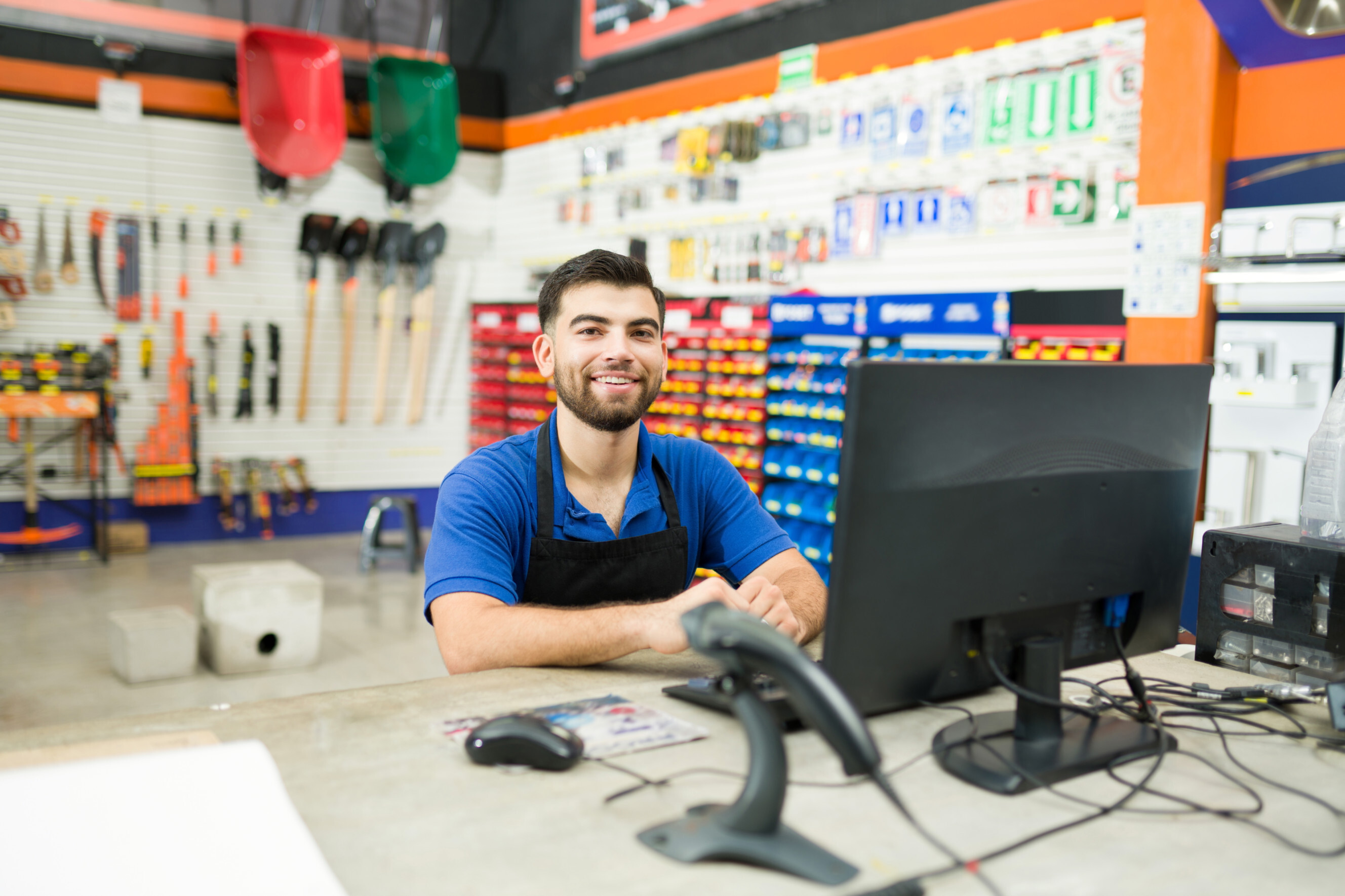 Friendly sales assistant working at a hardware store counter, highlighting professional sales assistants near you.