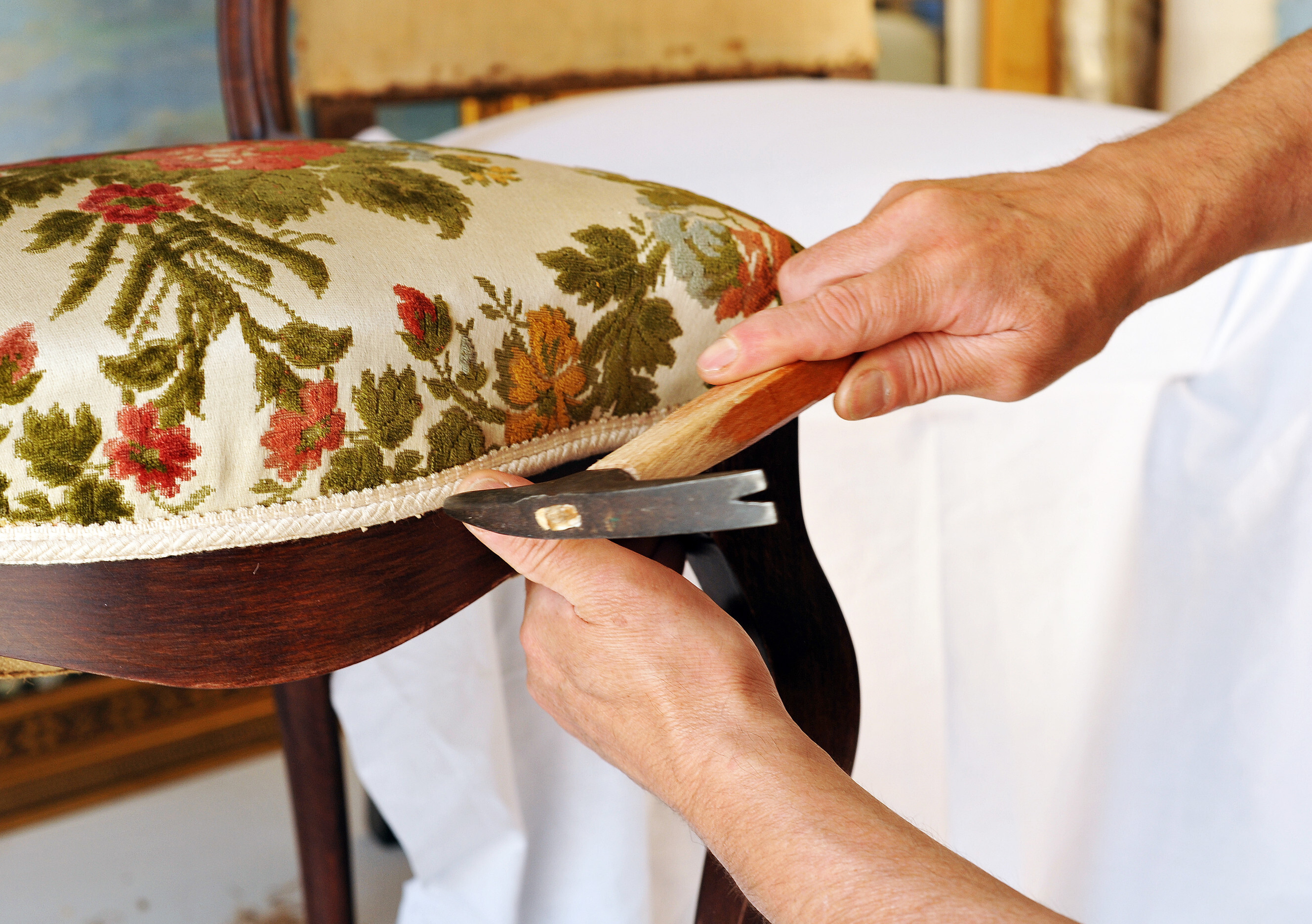 Skilled chair repair expert restoring the upholstery of a vintage chair, highlighting professional chair repair services near you.