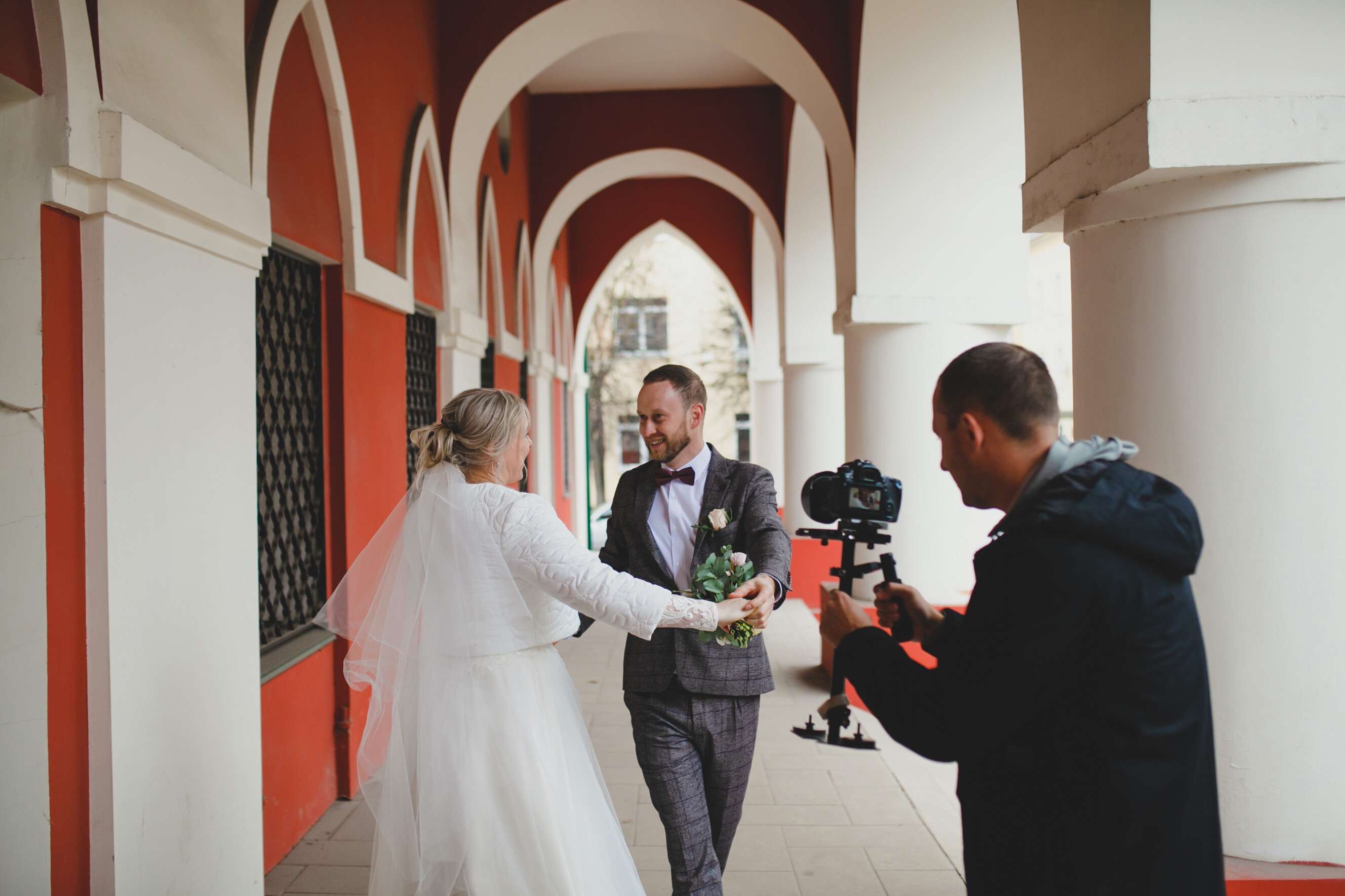 Wedding videographer capturing a joyful moment between a bride and groom, highlighting professional wedding videography services near you.