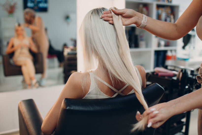 hair extensions cost - Girl getting hair extensions at a salon for a new look