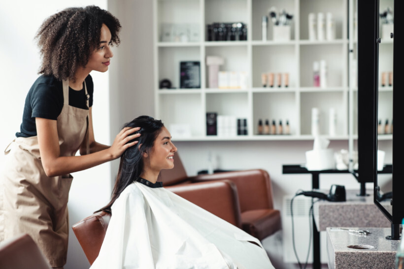 hair extensions cost - Hair stylist working with a girl in a salon