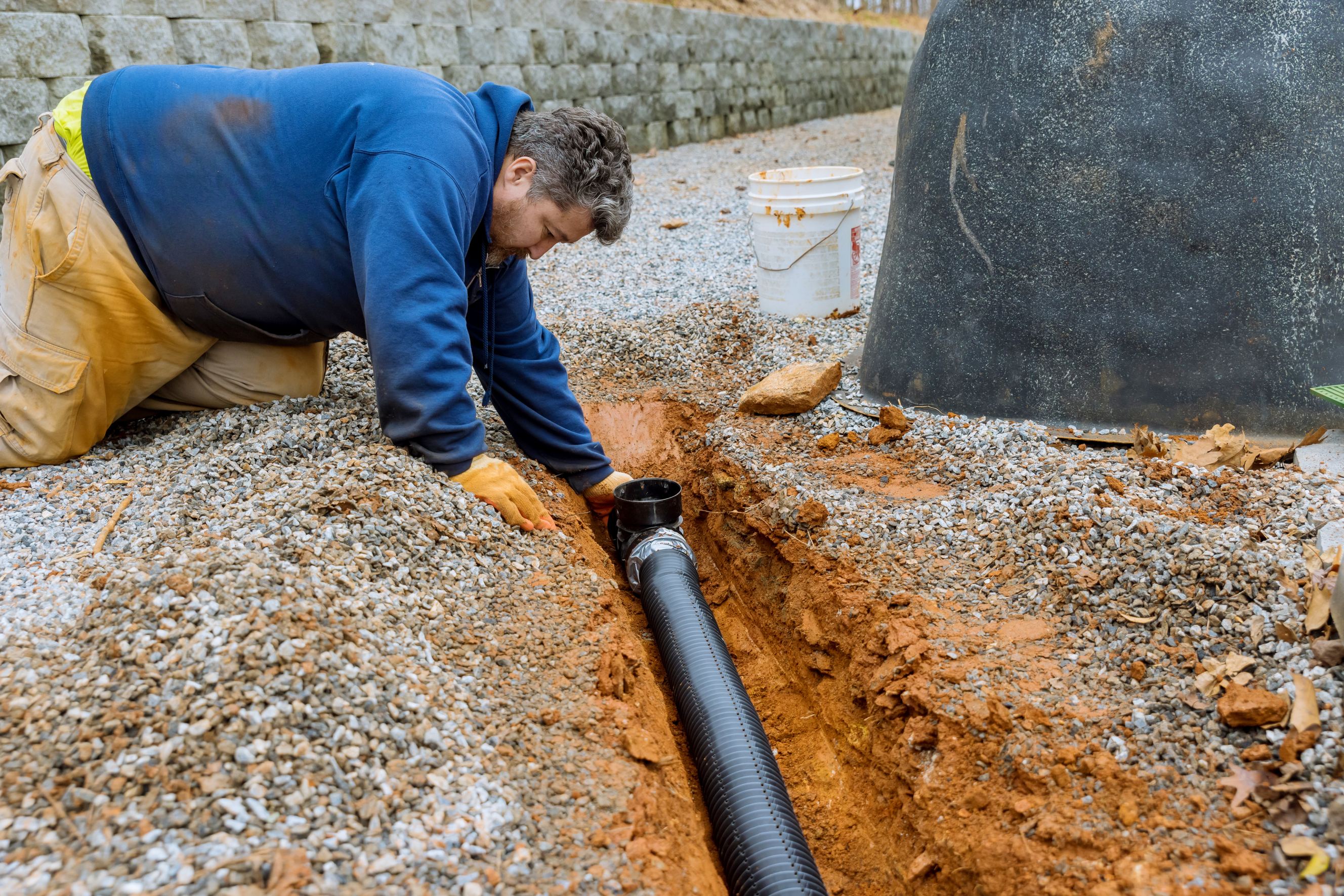 Assembling a drainage pipe for rain water collection symbolizes French drain installation.