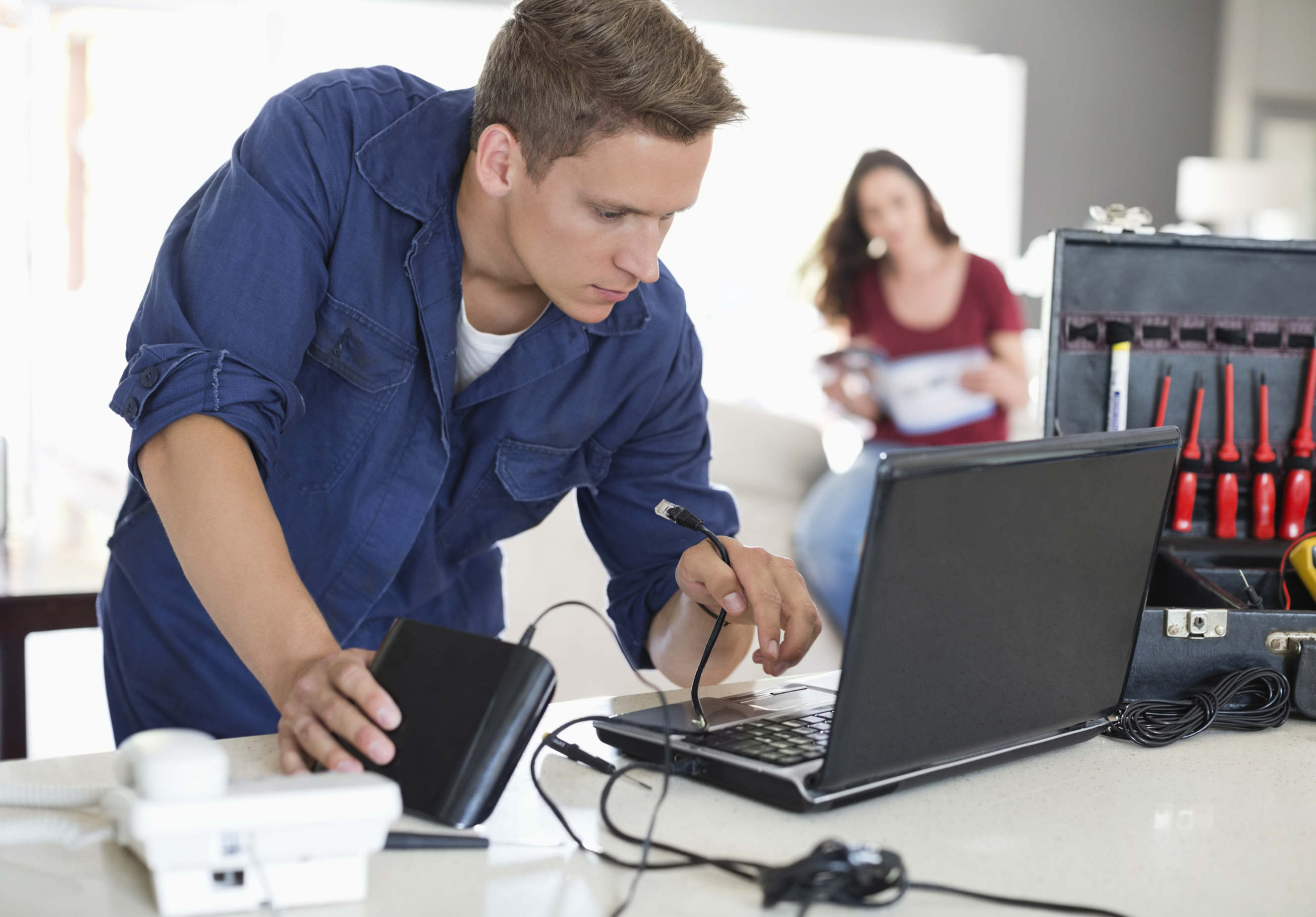 A broadband technician configuring an ADSL modem while troubleshooting connections.