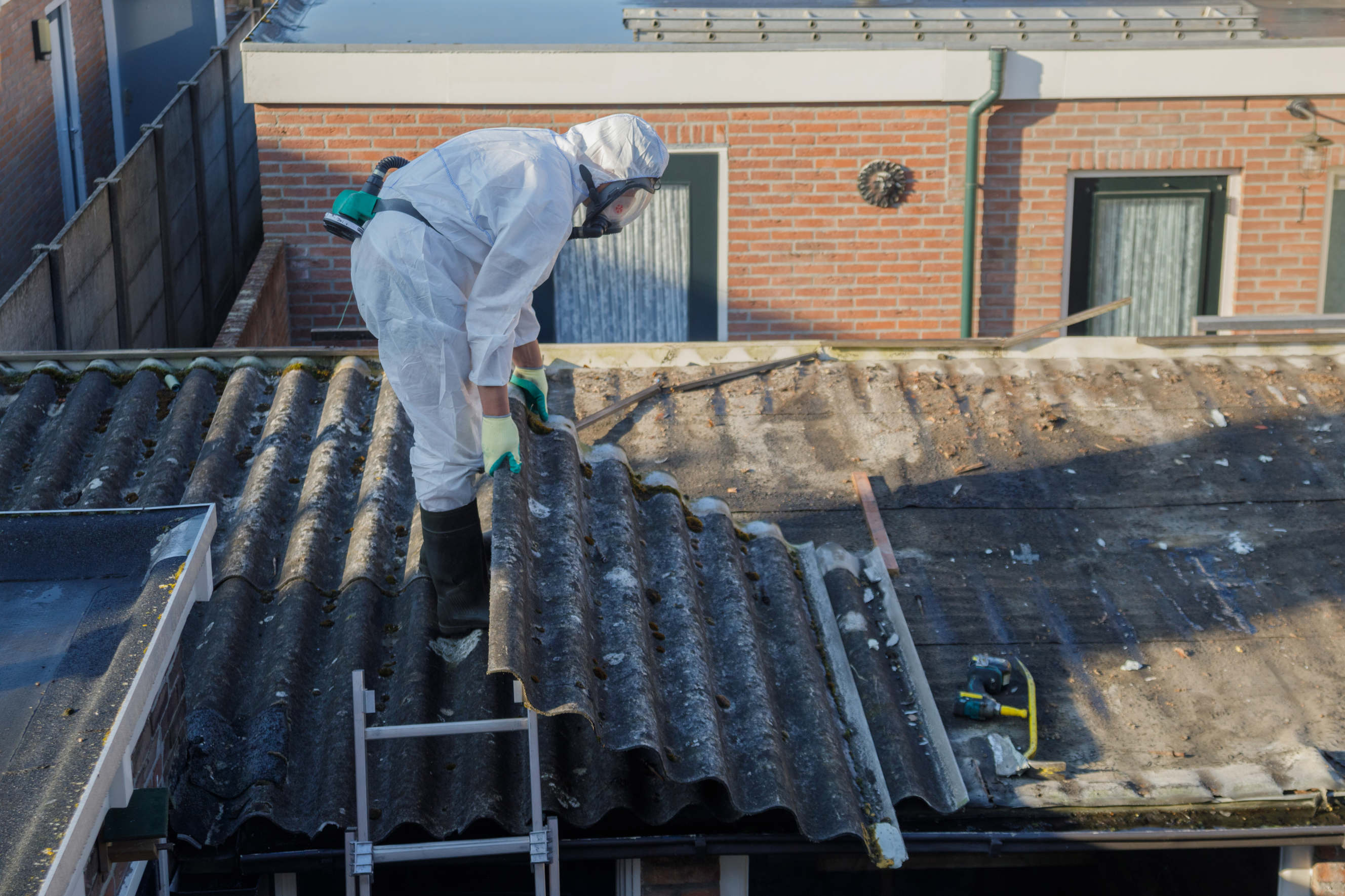  A specialist in full protective gear carefully handling asbestos removal.