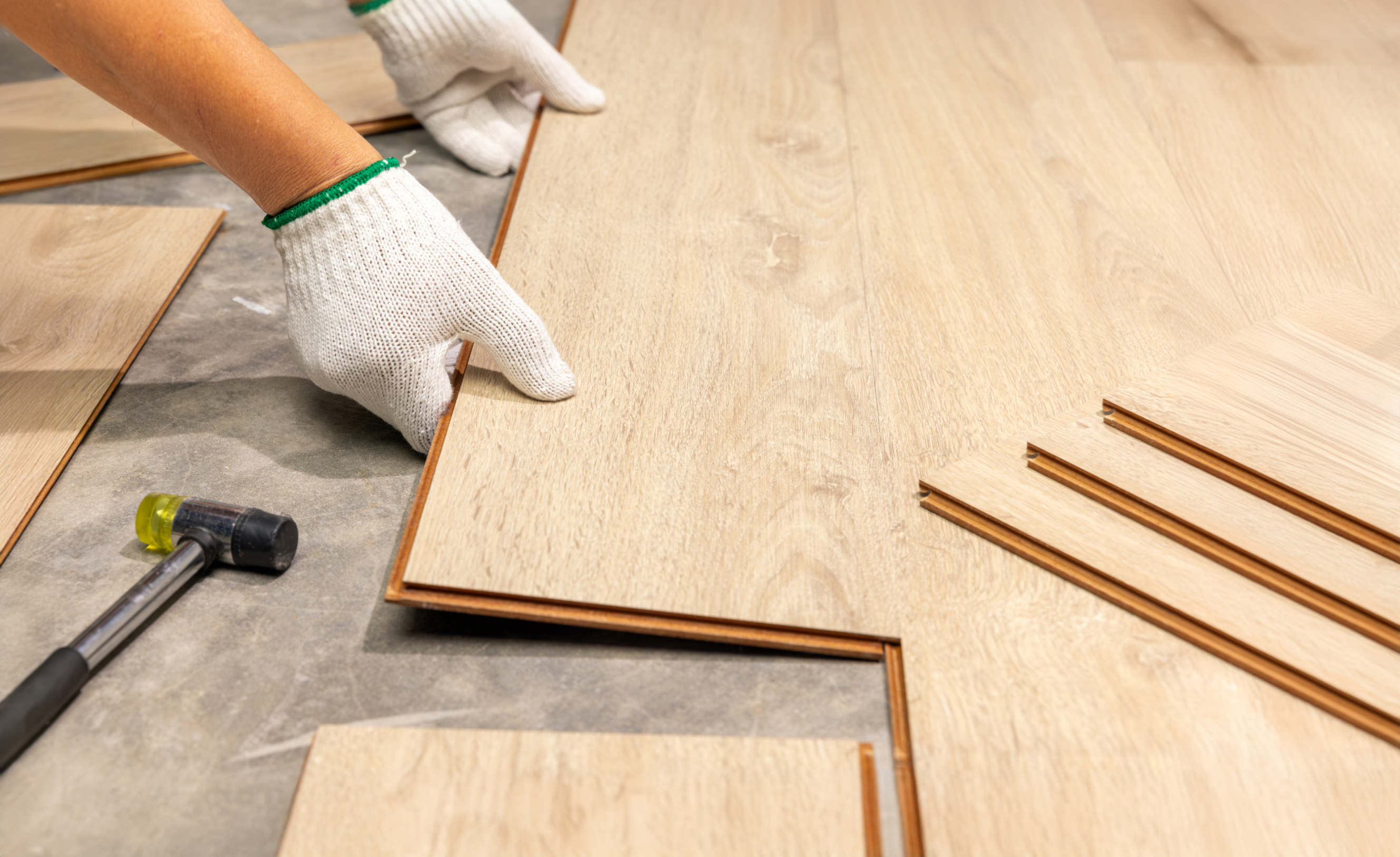 Worker installing bamboo flooring planks with precision.