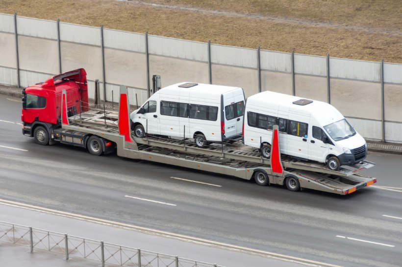 Car transport cost - A transport truck hauling minibuses