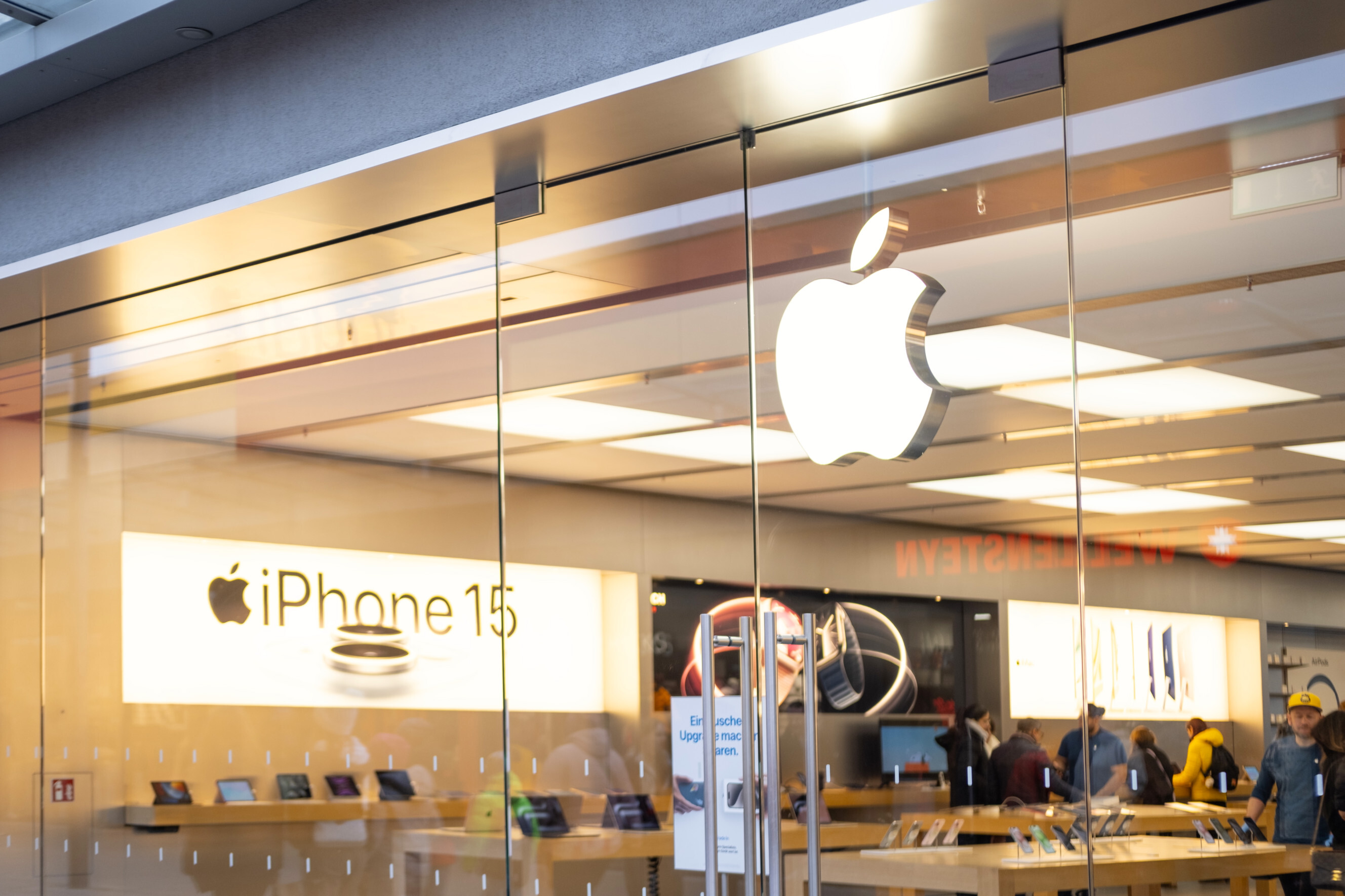 Outdoor view of an apple store with people buying inside