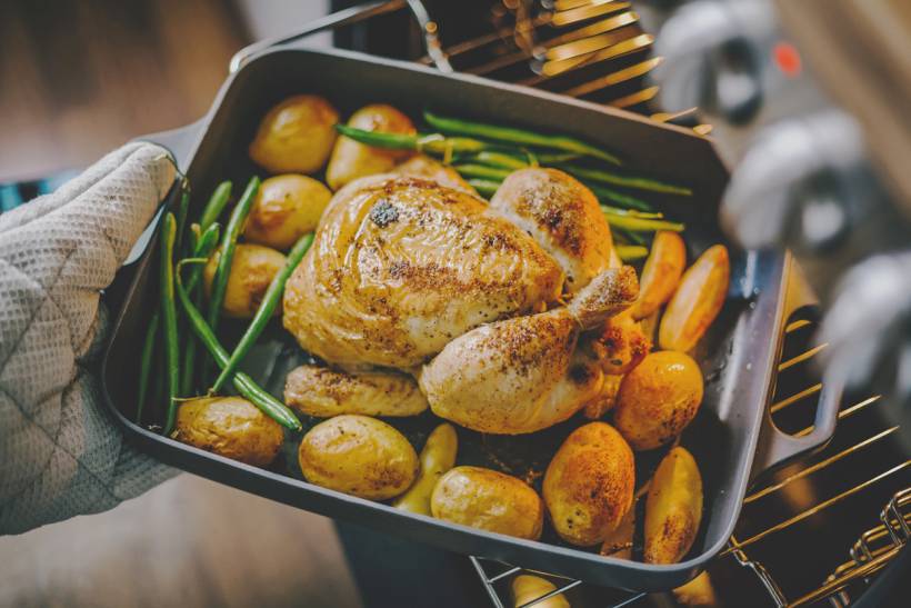 personal chef cost - a chef taking baked chicken from the oven