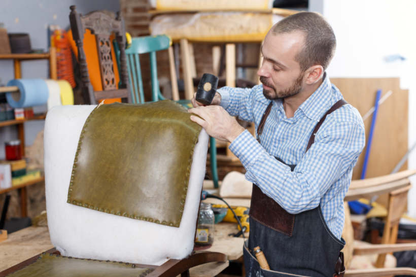 Cost to reupholster a chair - Furniture restoration expert upholstering a chairA skilled artisan transforms a chair with new upholstery. (Source: iStock)