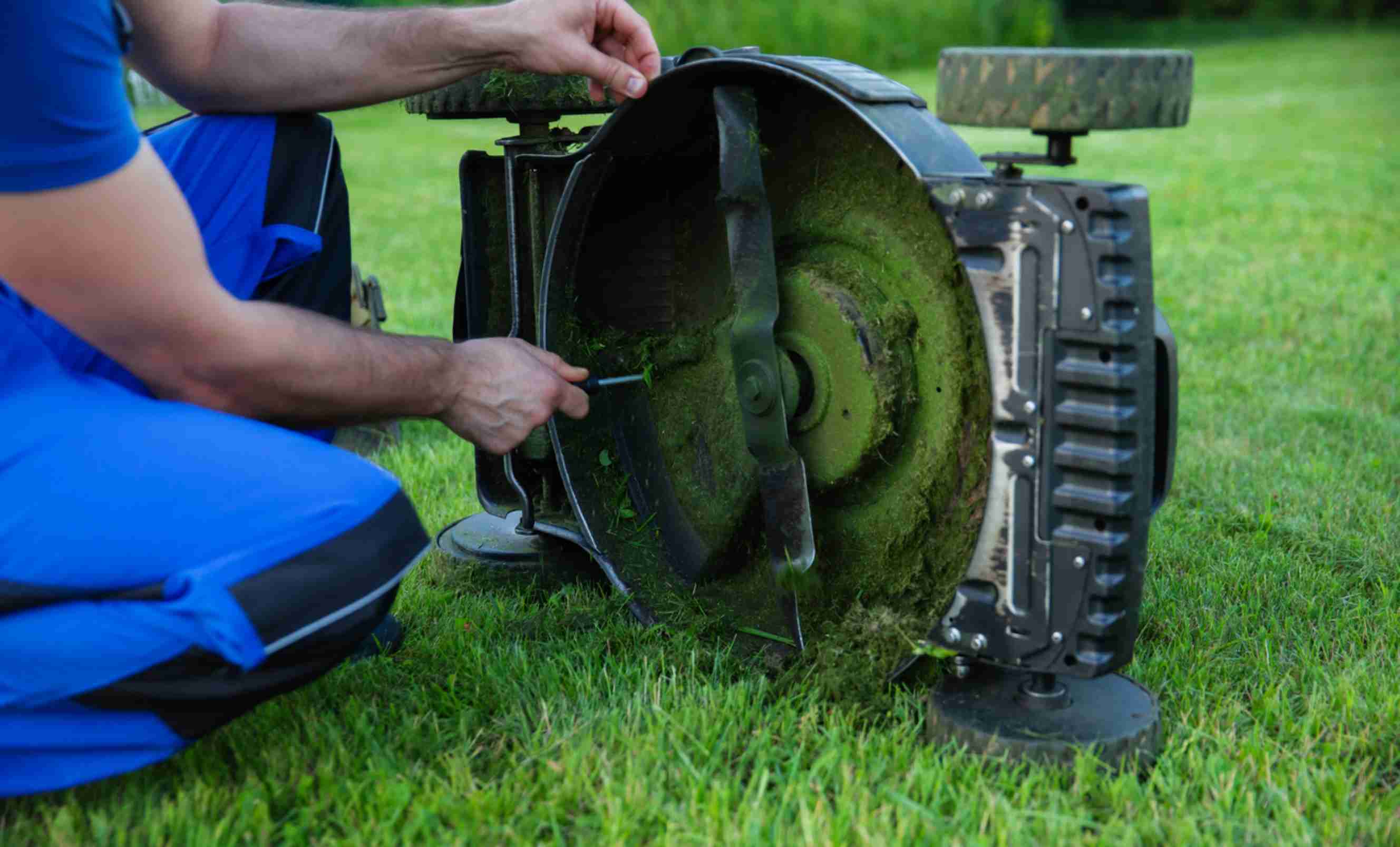 A professional servicing a lawn mower, representing garden machinery servicing near you.