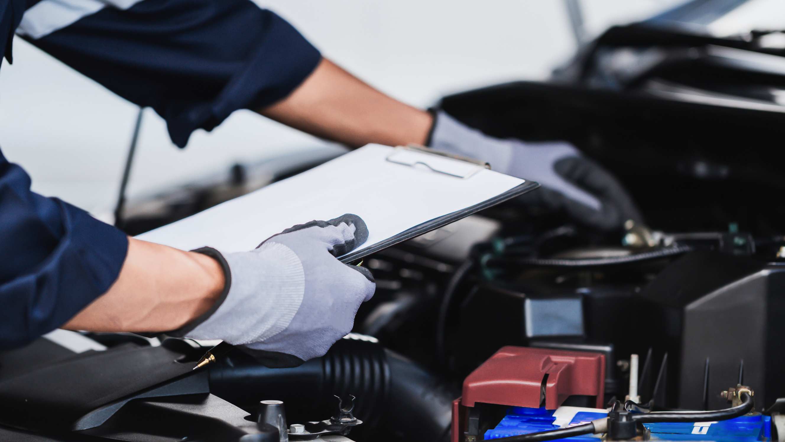 A mechanic performing a vehicle inspection with a clipboard, representing mobile car diagnostics near you