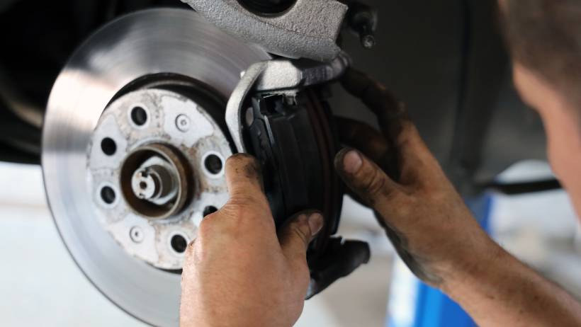 Close-up view of brake pad replacement on a silver brake disc - brake pad replacement cost