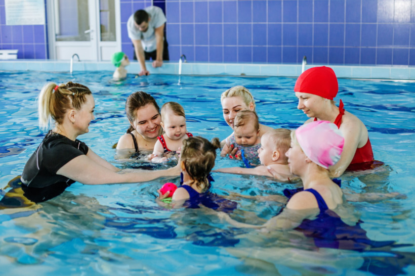 swimming lessons cost - Parent holding baby in water during a baby swim lesson