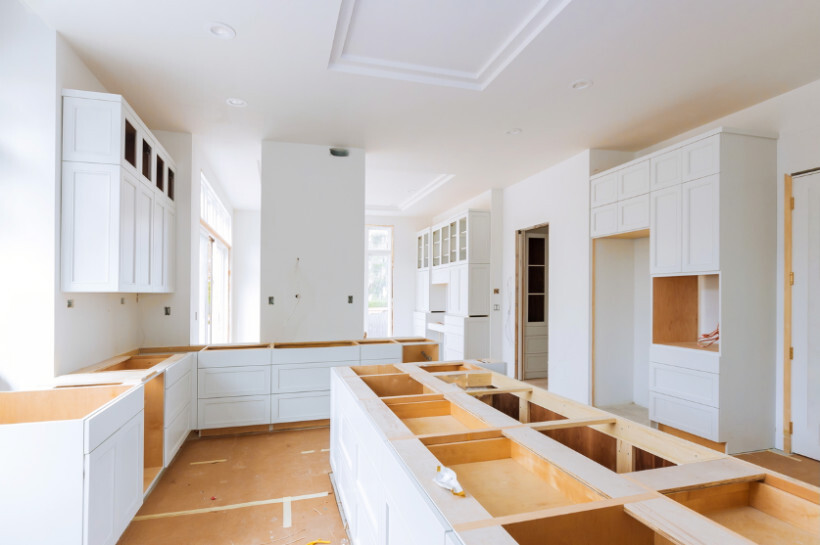IKEA kitchen cost - A large kitchen space mid-renovation, showing cabinet frames and layout without countertops