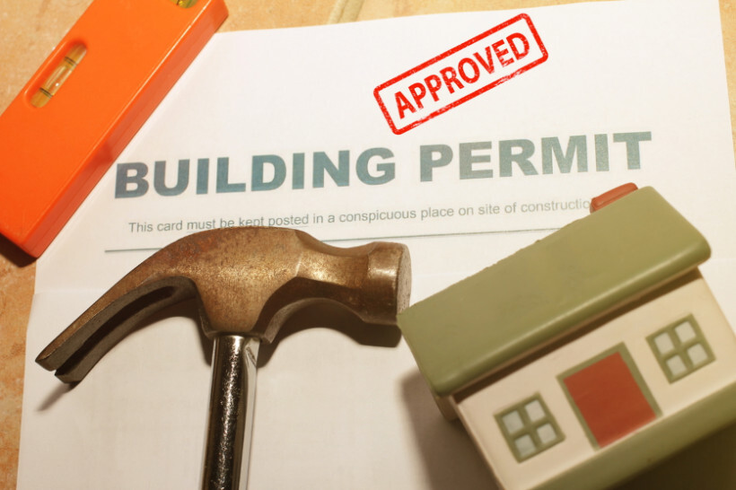IKEA kitchen cost - A close-up of a building permit marked "Approved" with a hammer and miniature house model