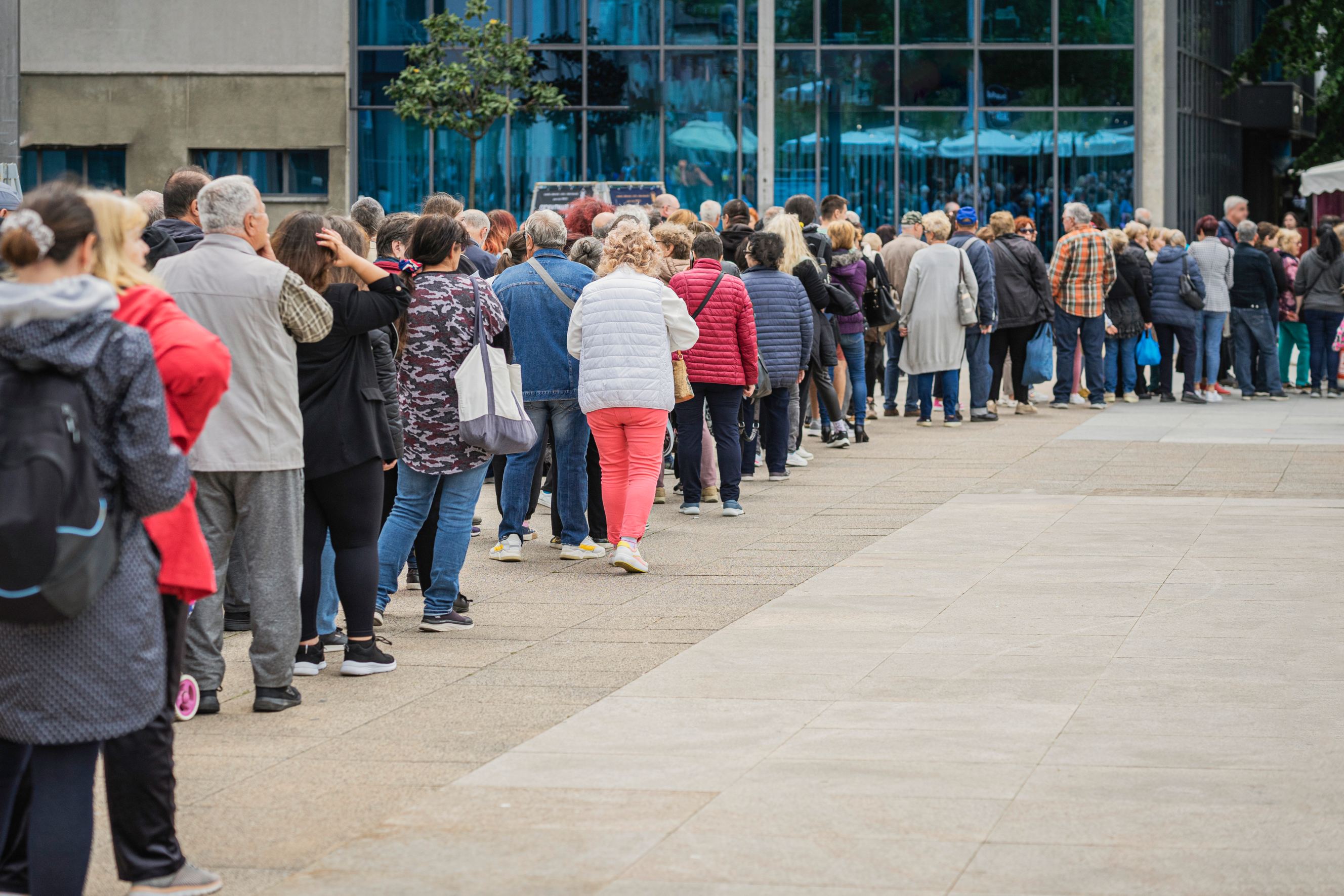 Long queue on a street, waiting patiently symbolizing a queuing service near me.