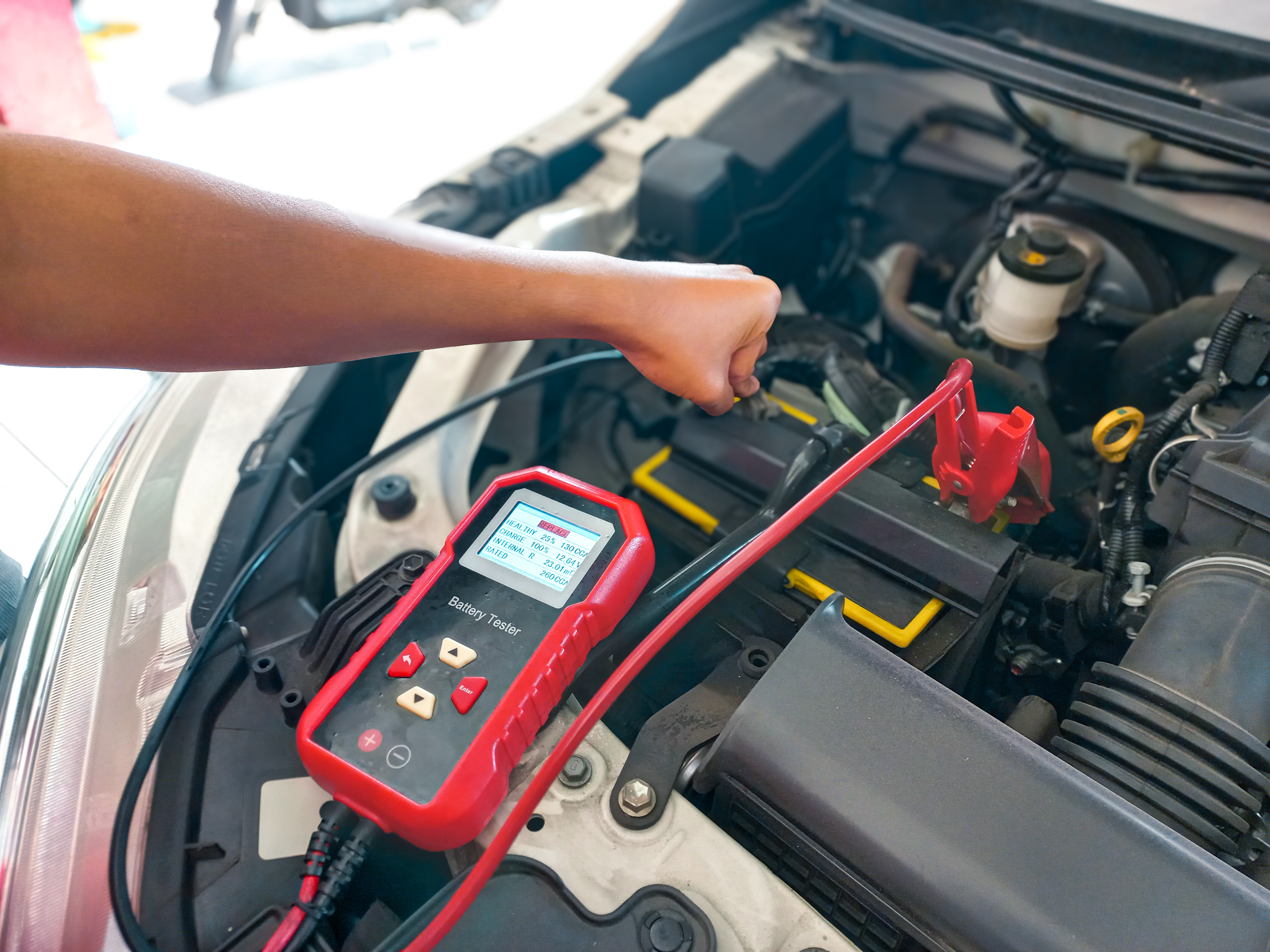 Car battery replacement cost - using a digital battery tester under the hood