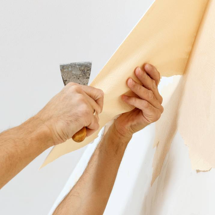 a man removing old wallpaper