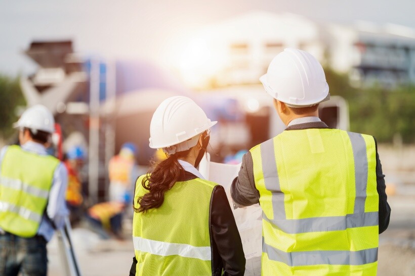 Building Surveyor vs Quantity Surveyor - Reviewing site plants while overseeing construction progress