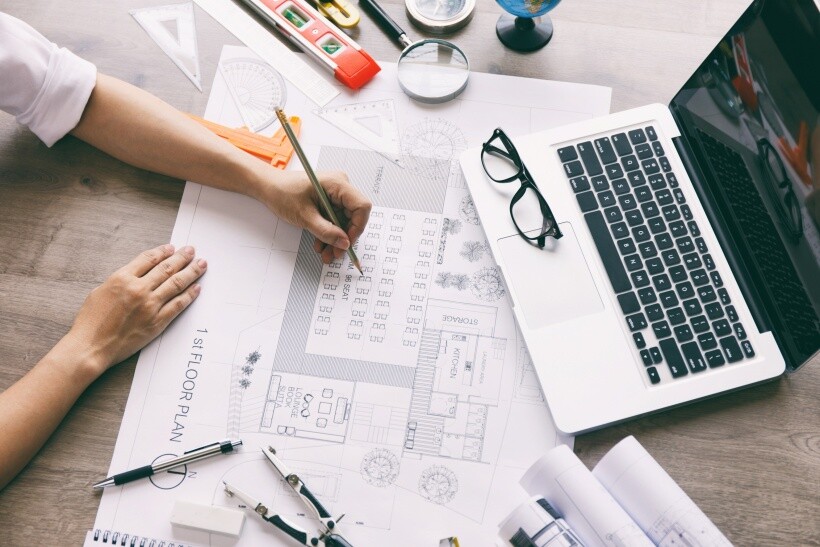 Building Surveyor vs Quantity Surveyor - Quantity surveyor working on cost estimates and floor plan measurements