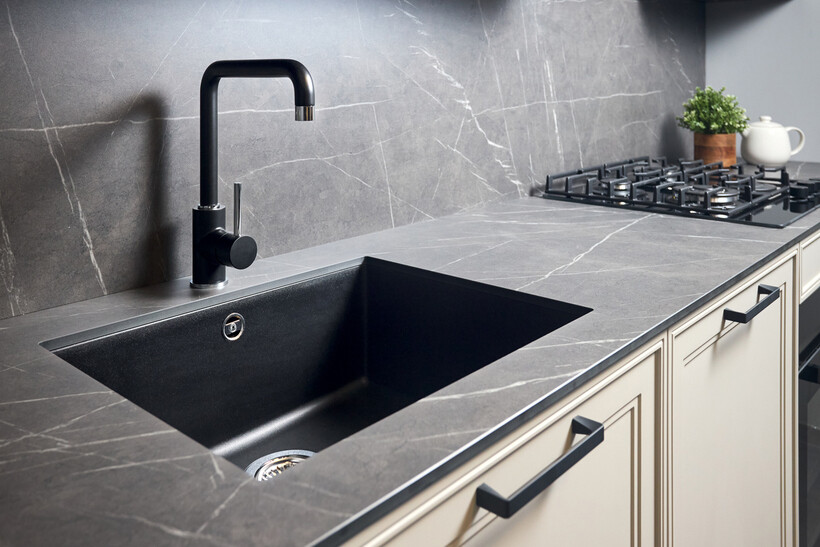 Kitchen sink with black faucet and gray stone countertop. - sink vs basin
