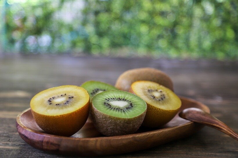golden kiwi vs green kiwi - Fresh golden and green kiwifruit arranged on a rustic table