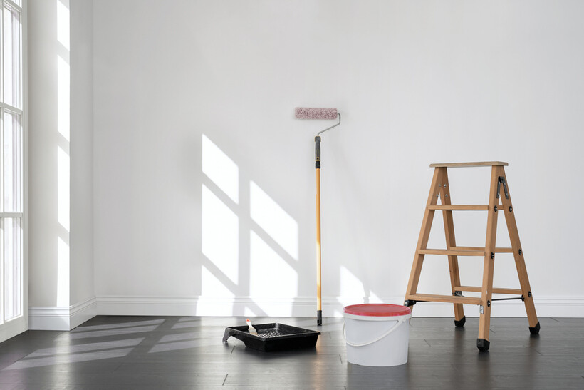 Refurbishment scene with paint roller, bucket, and ladder ready for wall painting. - refurbishment vs renovation
