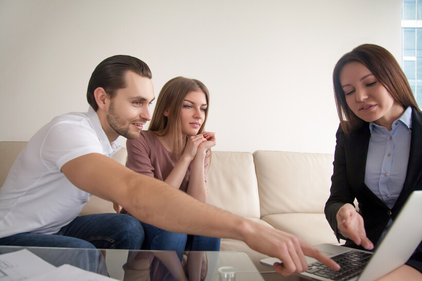 Couple meeting with a wedding planner and reviewing details on a laptop. - wedding planner vs wedding coordinator
