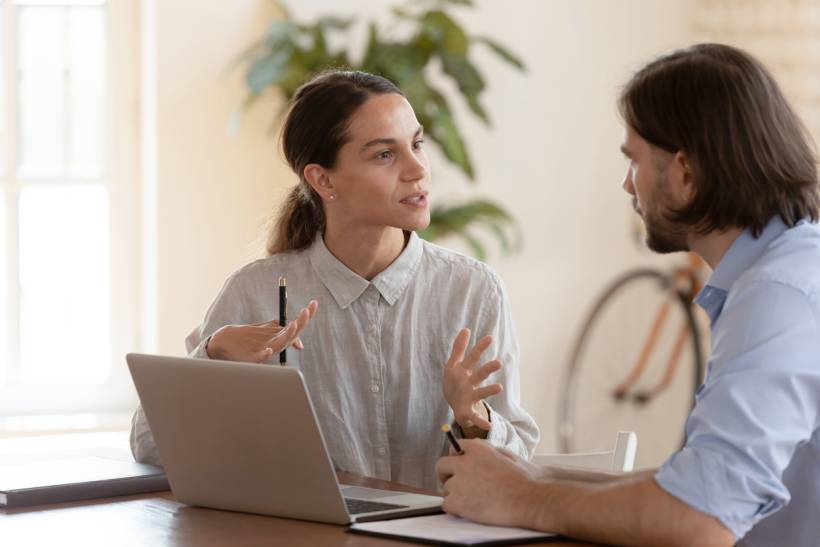 life coach vs career coach - Career coach providing guidance to a client during a consultation at a desk