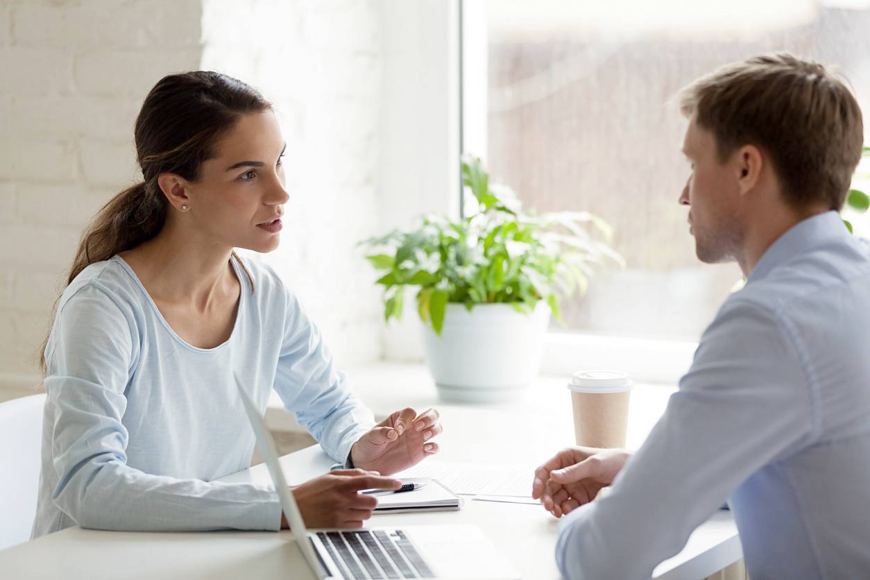 life coach vs career coach - Female career coach talking with a male client during a professional meeting